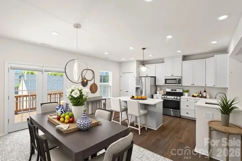 a view of a kitchen with dining table appliances and a chandelier