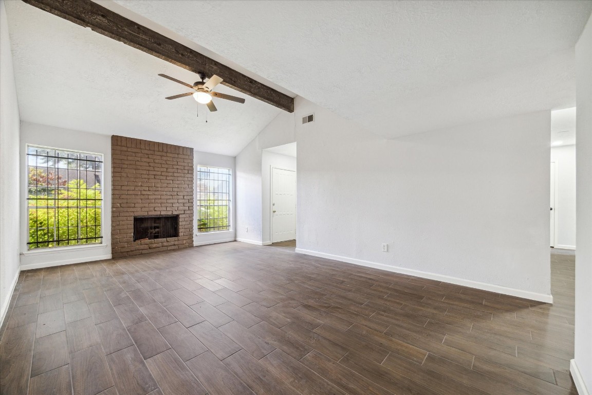8628 Maplecrest Drive Houston, TX 77099 - Photo 5 of 10 a view of empty room with fireplace and wooden floor