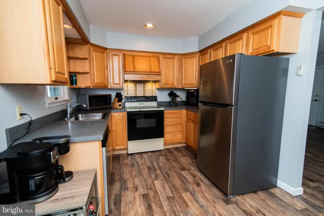 a kitchen with stainless steel appliances granite countertop a refrigerator stove top oven and sink