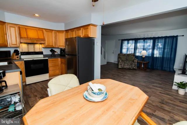 a kitchen with stainless steel appliances wooden floor dining table and chairs