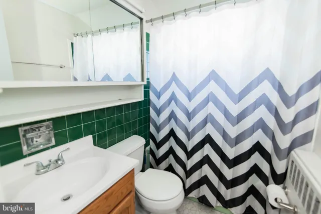 a bathroom with a sink a toilet and shower curtain