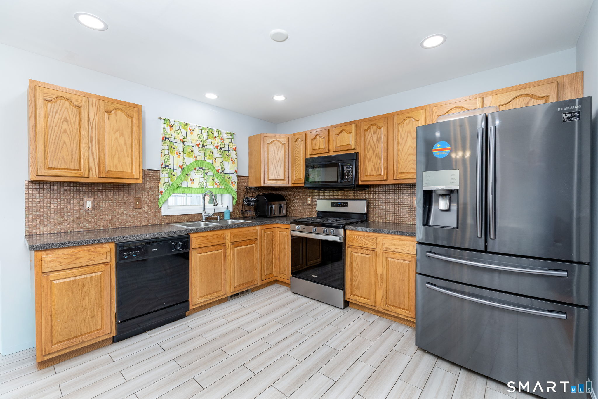 234 Traverse Street Waterbury, CT 06704 - Photo 12 of 38 a kitchen with granite countertop stainless steel appliances cabinets a sink and a window