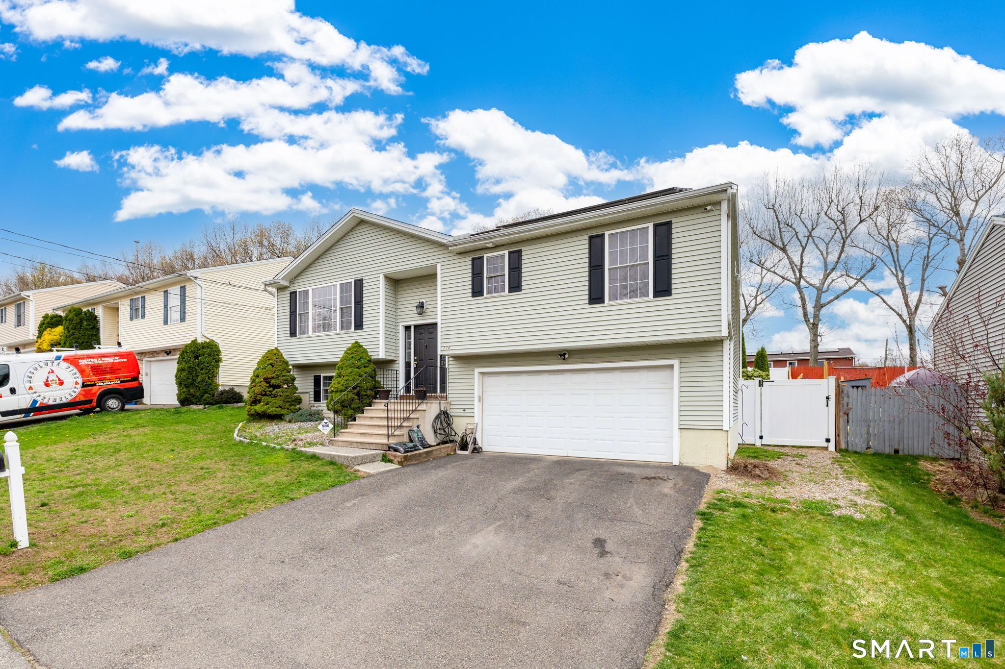 234 Traverse Street Waterbury, CT 06704 - Photo 2 of 38 a front view of a house with a garden and trees