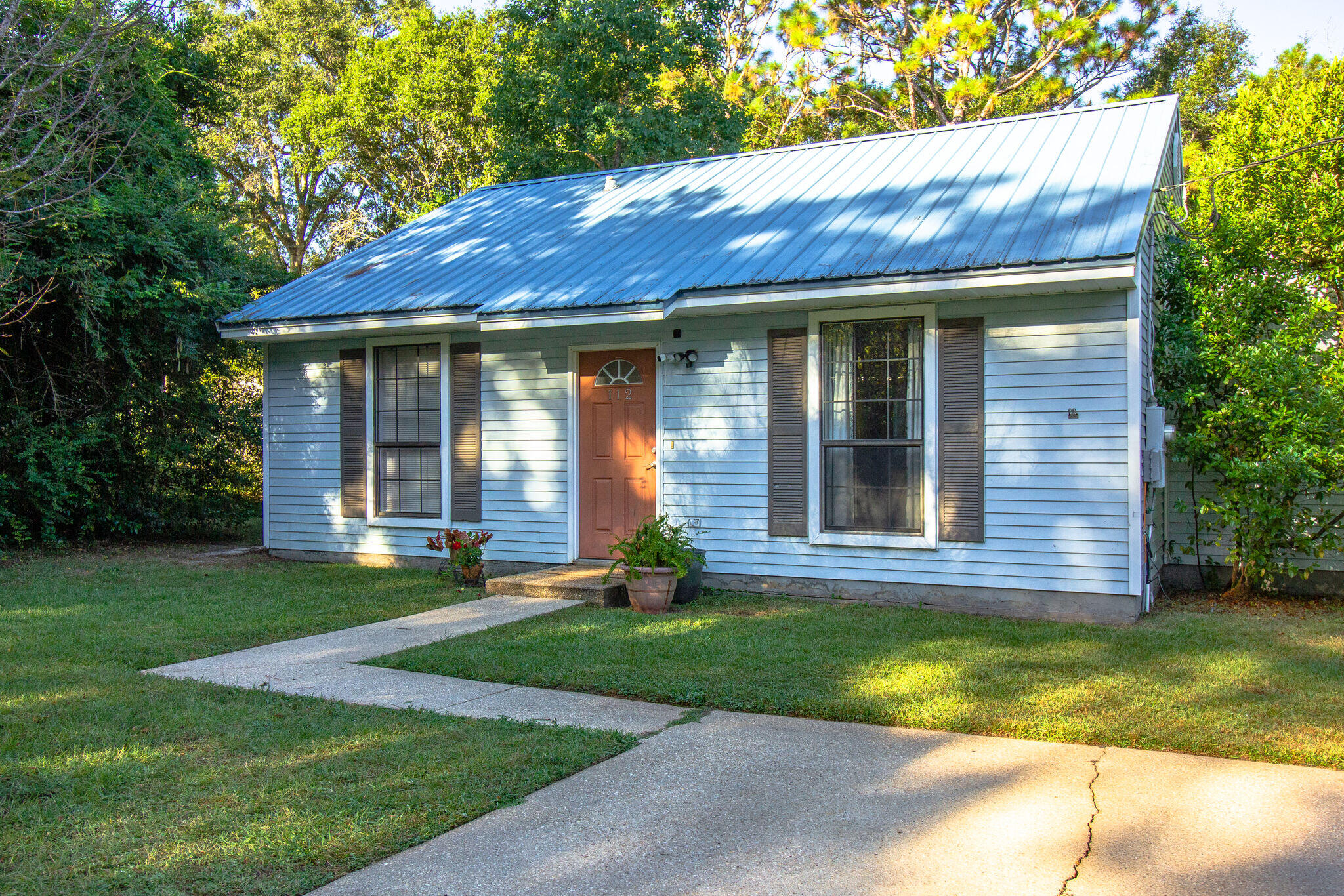 112 James Street Crestview, FL 32536 - Photo 1 of 16 a view of brick house with a yard potted plants and a table and chairs