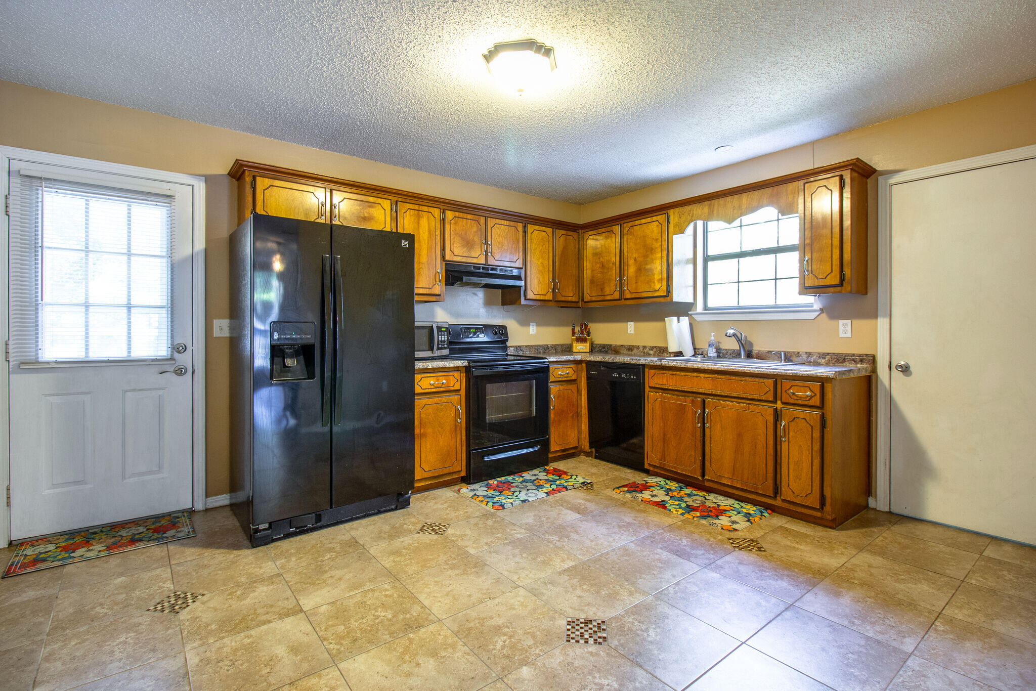 112 James Street Crestview, FL 32536 - Photo 7 of 16 a kitchen with stainless steel appliances granite countertop a stove top oven a sink dishwasher a refrigerator and cabinets with wooden floor
