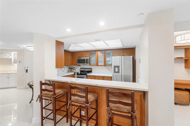 a room with wooden cabinets and stainless steel appliances
