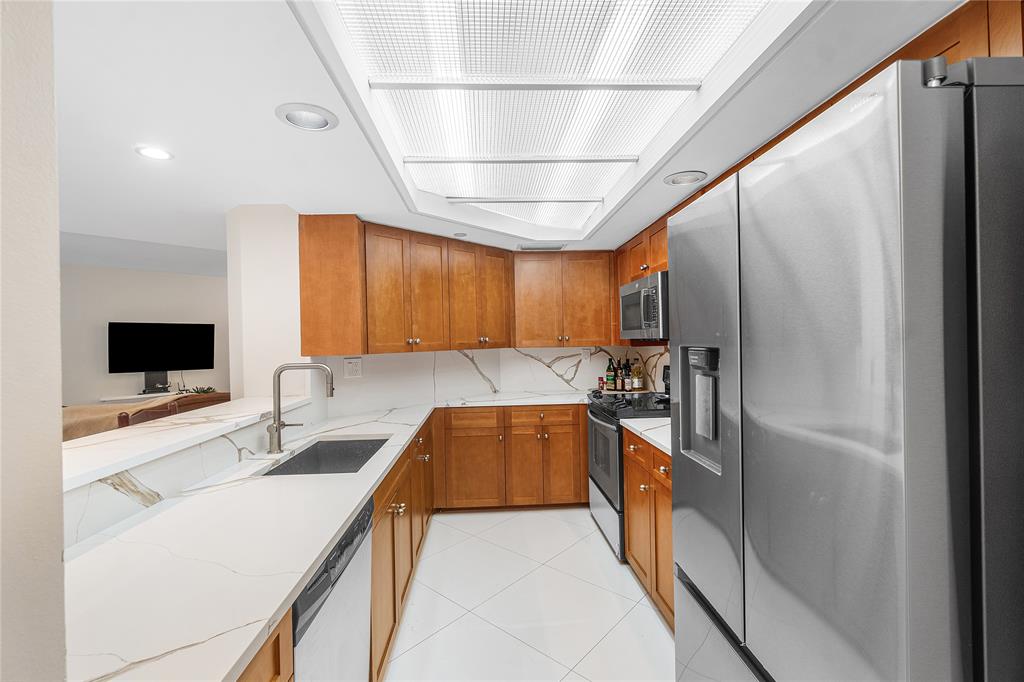 100 Southeast 5th Avenue, Unit 110 Boca Raton, FL 33432 - Photo 16 of 52 a kitchen with stainless steel appliances granite countertop a sink and a refrigerator