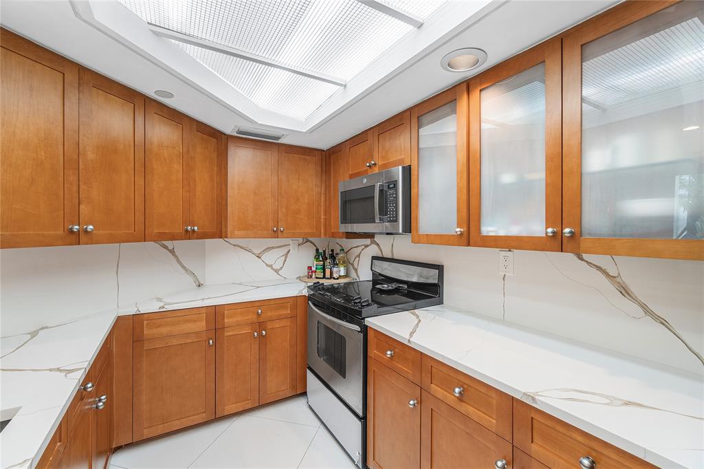 100 Southeast 5th Avenue, Unit 110 Boca Raton, FL 33432 - Photo 18 of 52 a kitchen with a sink a stove cabinets and a wooden floor