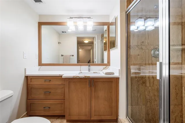 a bathroom with a shower sink and mirror