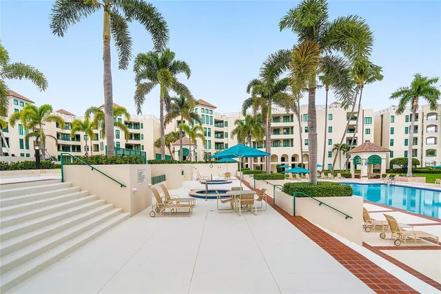 a view of a swimming pool with a lounge chair and palm trees