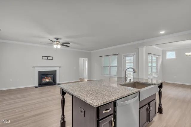 a kitchen with a kitchen island a sink stainless steel appliances and wooden floor