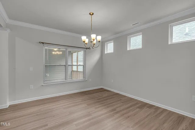 a view of wooden floor in an empty room with a window