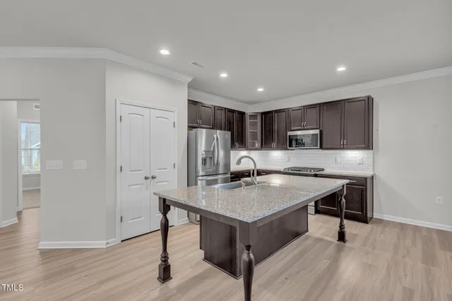 a kitchen with a refrigerator a sink and a cabinets