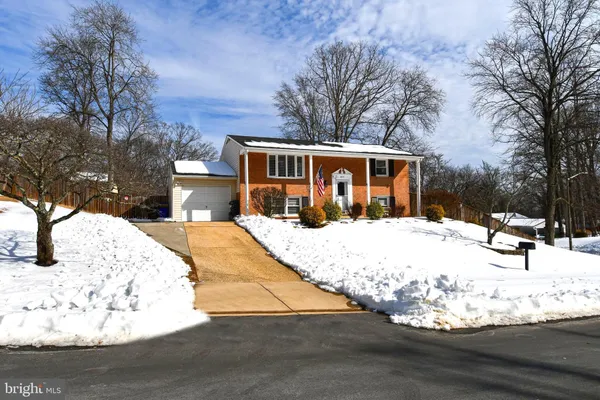 a view of a house with snow on the side of the road