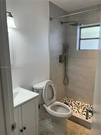 a bathroom with a granite countertop sink toilet and shower