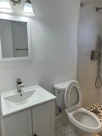 a bathroom with a toilet sink and mirror