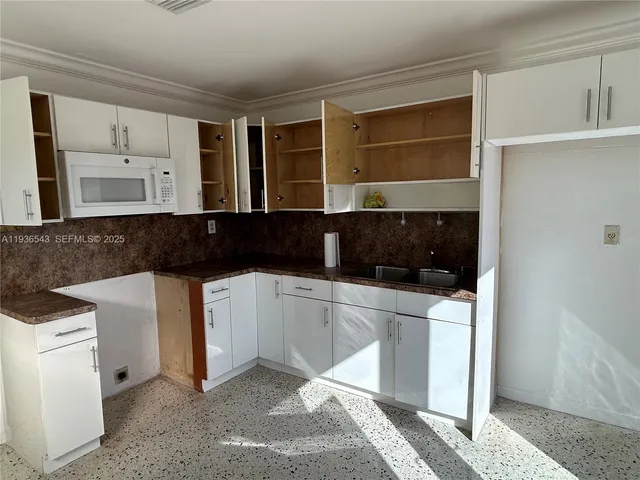 a kitchen with a refrigerator and a stove top oven