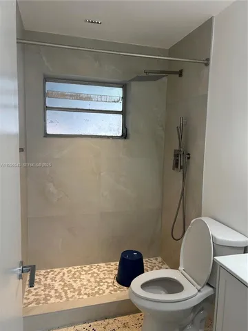 a bathroom with a toilet and a shower