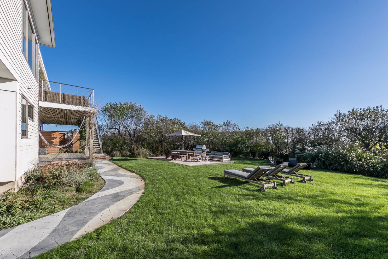 83 North Surfside Avenue Montauk, NY 11954 - Photo 22 of 26 a backyard of a house with table and chairs