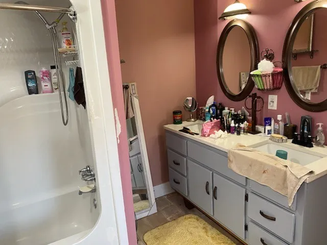 a bathroom with a sink mirror and a bathtub