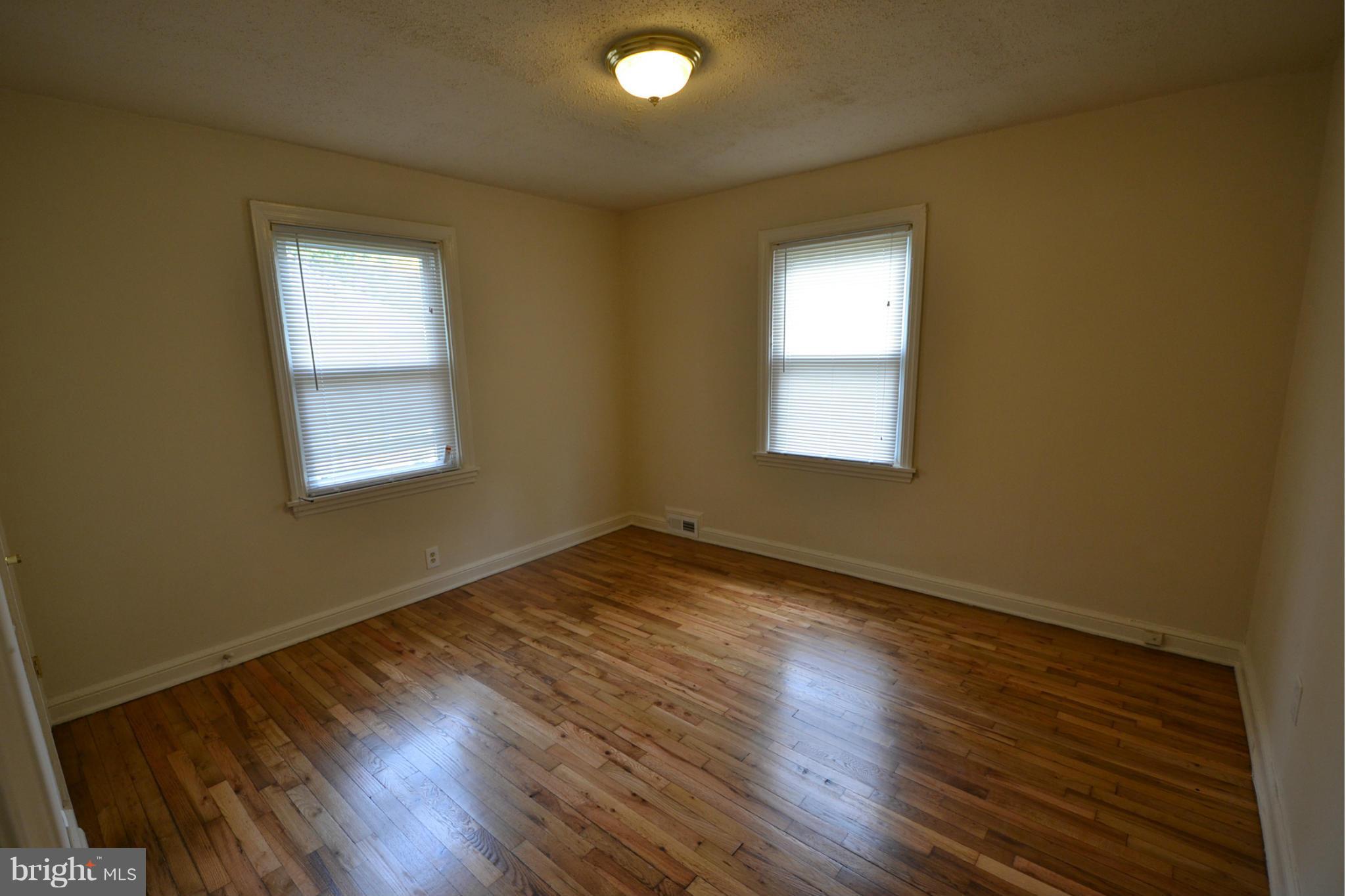 2504 Steele Road Baltimore, MD 21209 - Photo 12 of 21 an empty room with wooden floor and windows