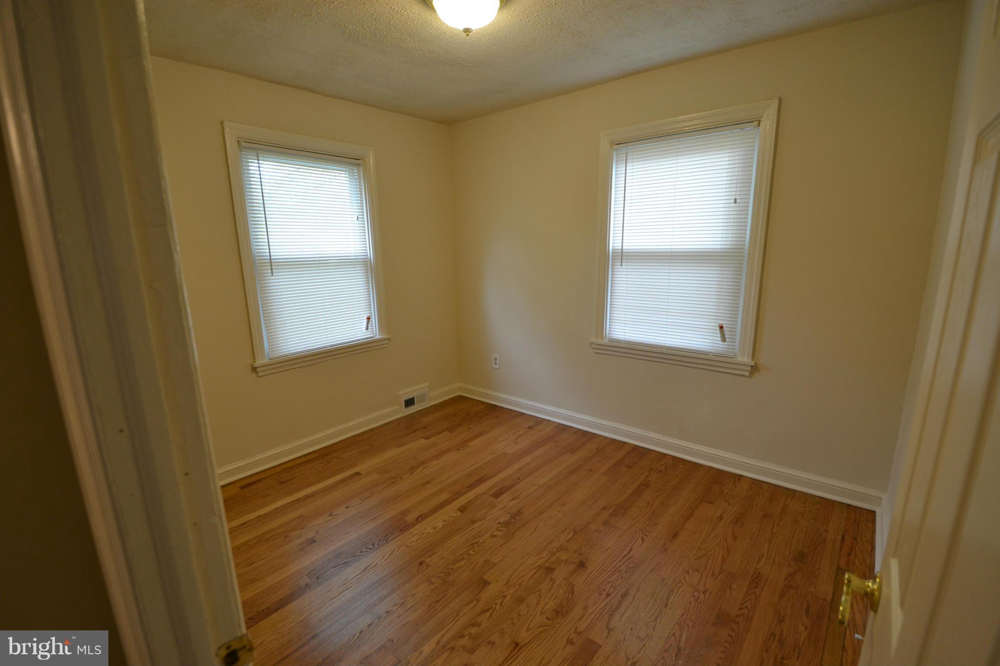 2504 Steele Road Baltimore, MD 21209 - Photo 13 of 21 a view of an empty room with wooden floor and a window