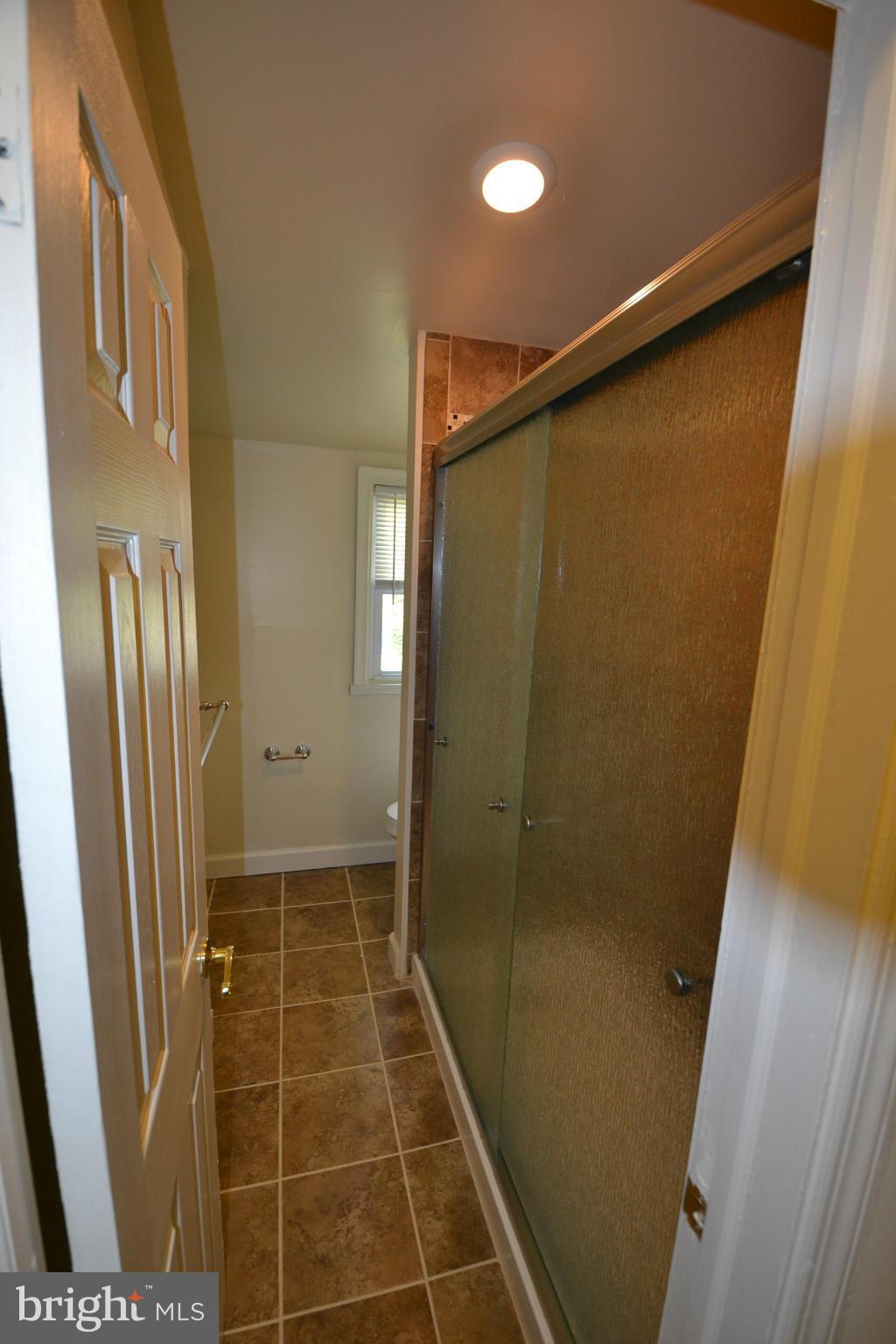 2504 Steele Road Baltimore, MD 21209 - Photo 18 of 21 a bathroom with a shower and a glass door