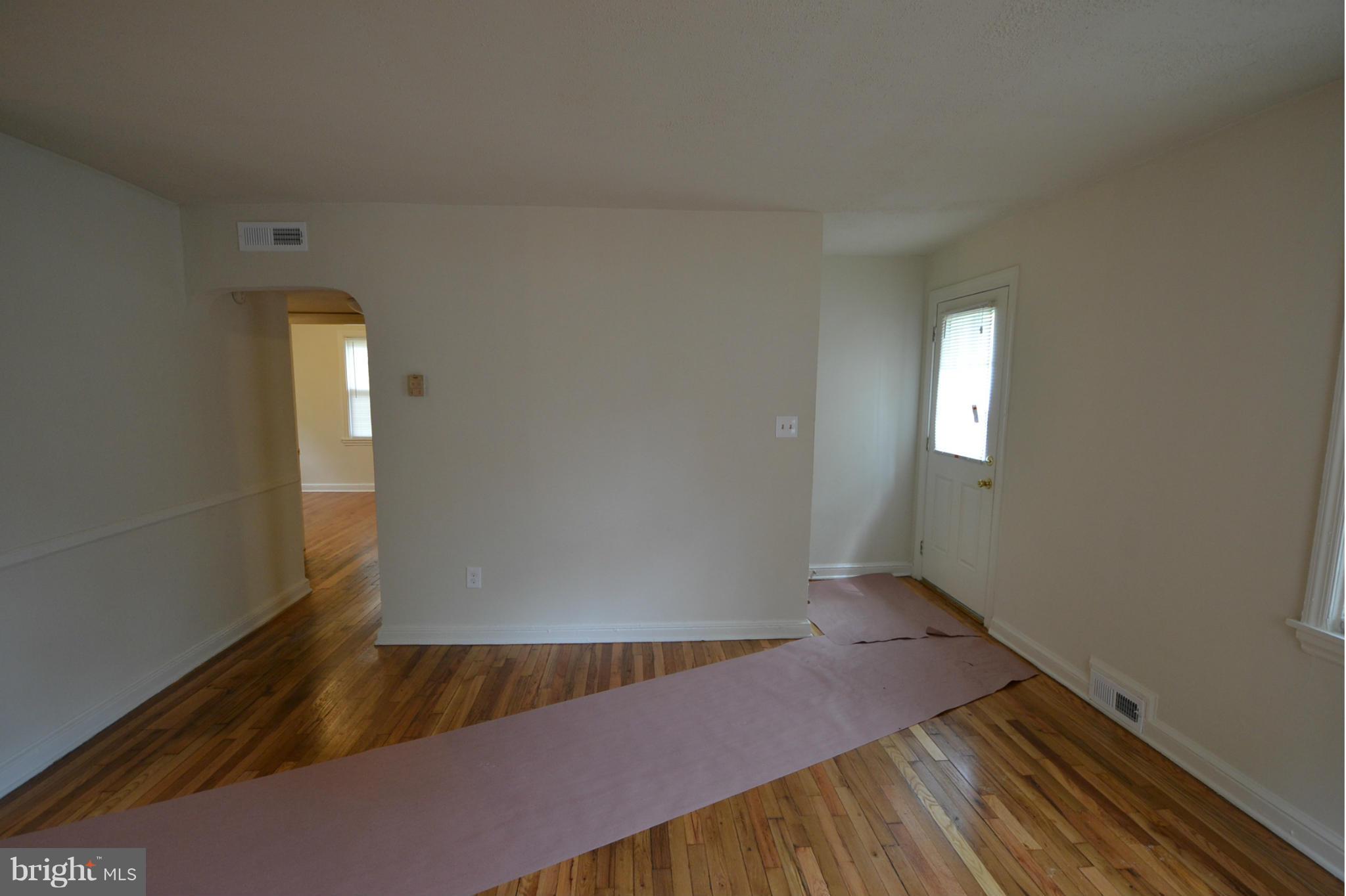 2504 Steele Road Baltimore, MD 21209 - Photo 4 of 21 an empty room with wooden floor and windows