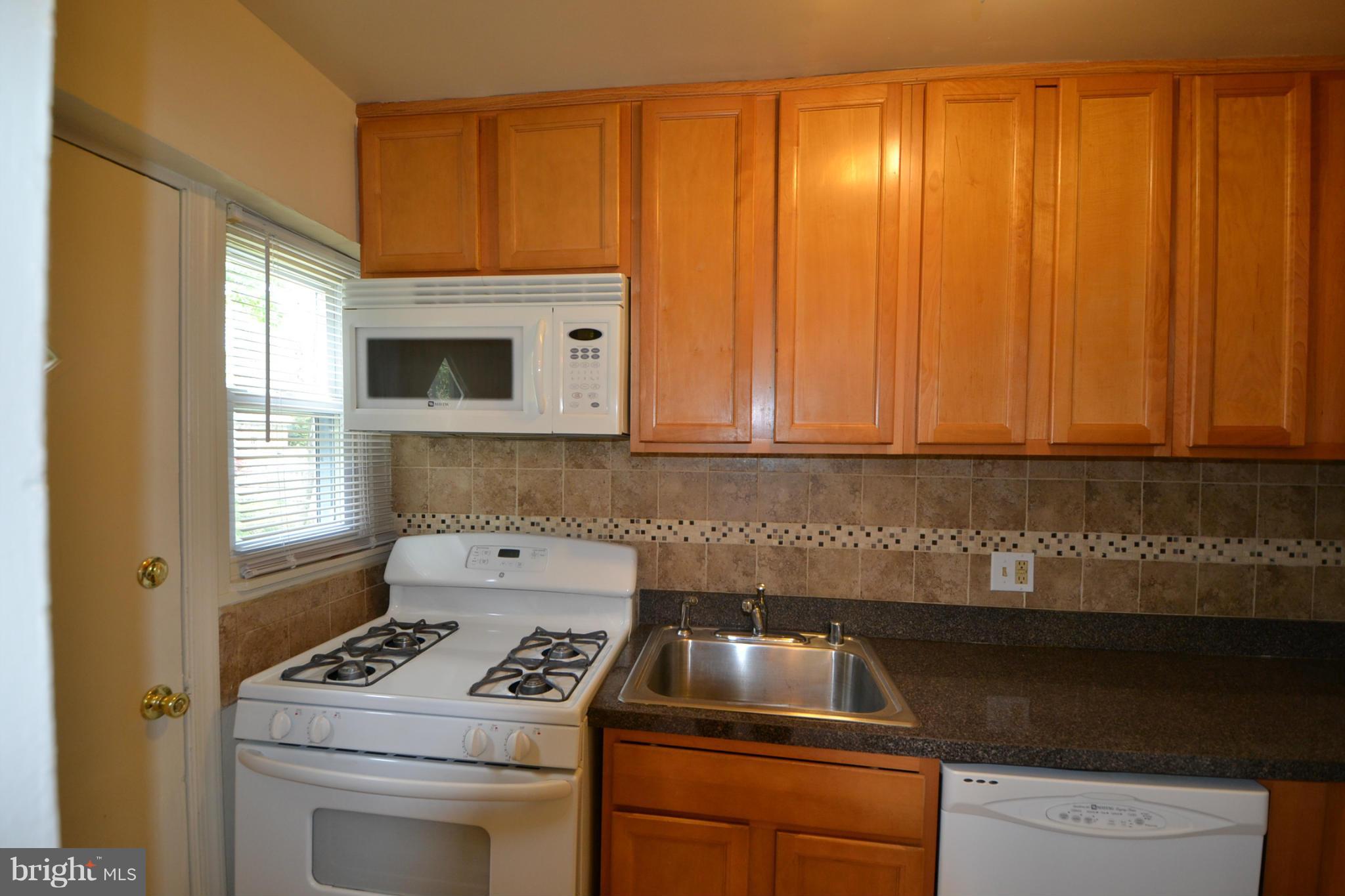 2504 Steele Road Baltimore, MD 21209 - Photo 7 of 21 a kitchen with a sink a stove and cabinets