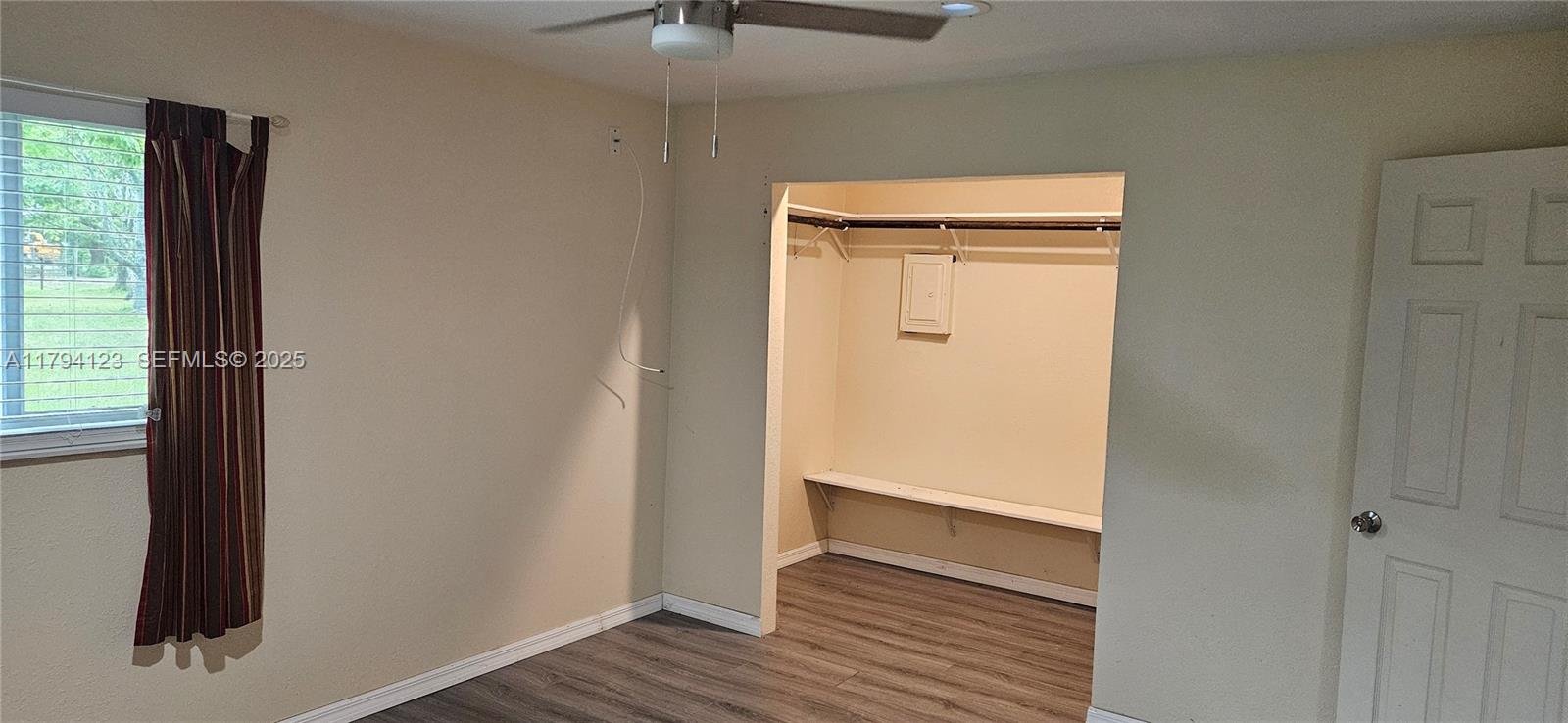3100-3112 Sanders Road Davenport, FL 33837 - Photo 73 of 100 a view of an empty room with wooden floor and a window