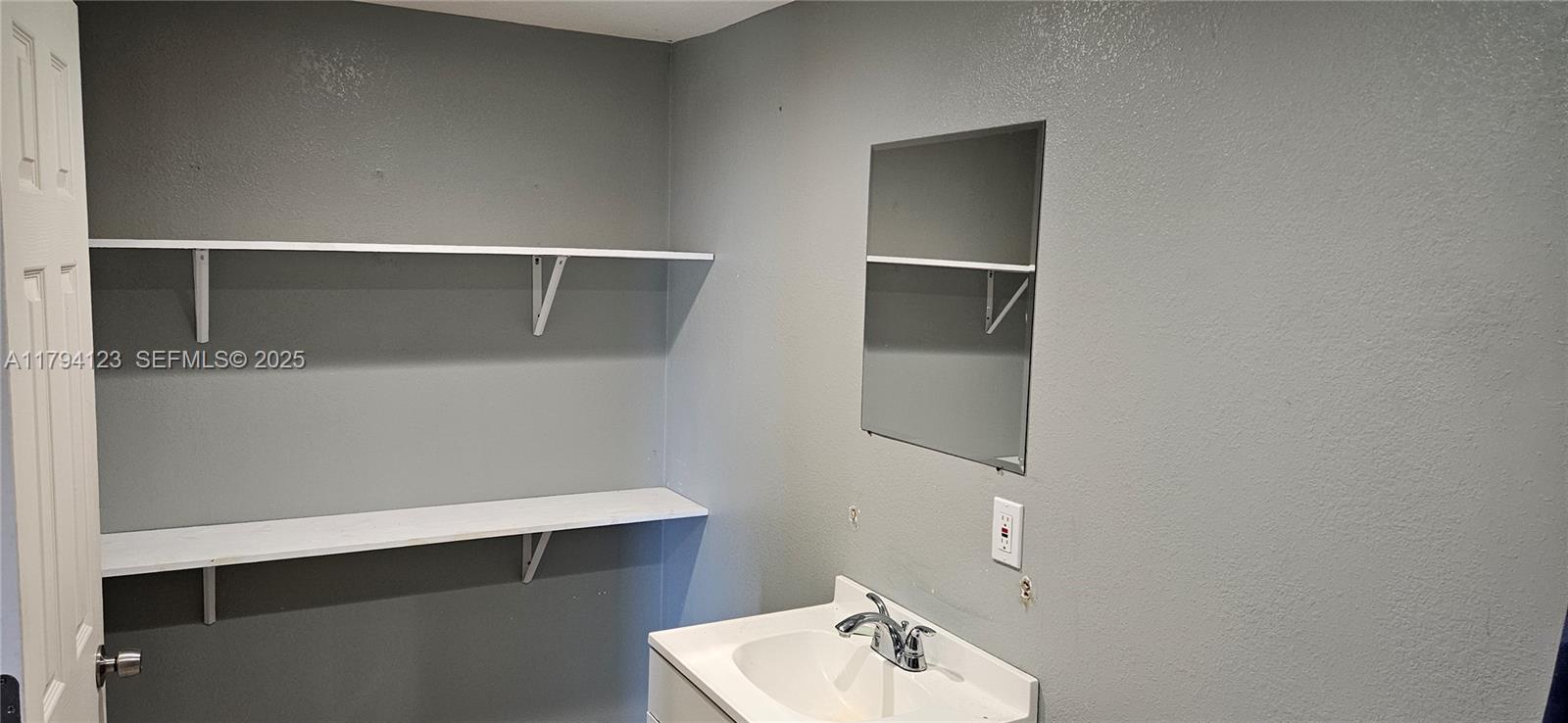 3100-3112 Sanders Road Davenport, FL 33837 - Photo 75 of 100 a bathroom with a sink and mirror