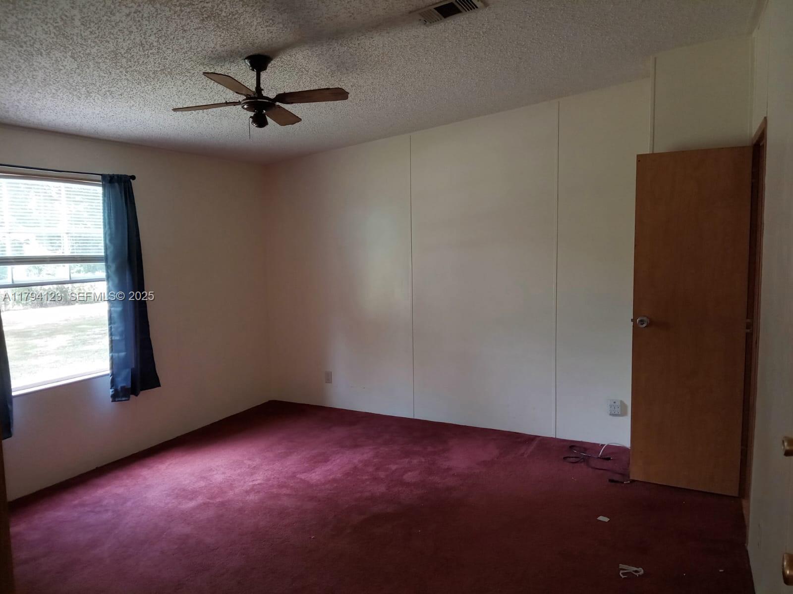 3100-3112 Sanders Road Davenport, FL 33837 - Photo 77 of 100 an empty room with a window and a ceiling fan