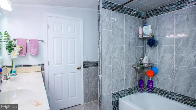 a bathroom with a sink vanity mirror and shower