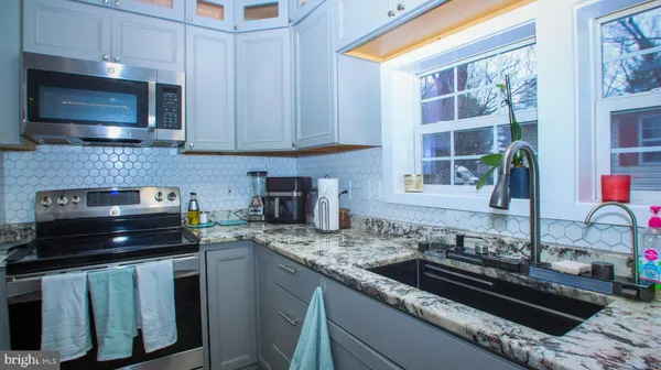 a kitchen with granite countertop a stove and a sink
