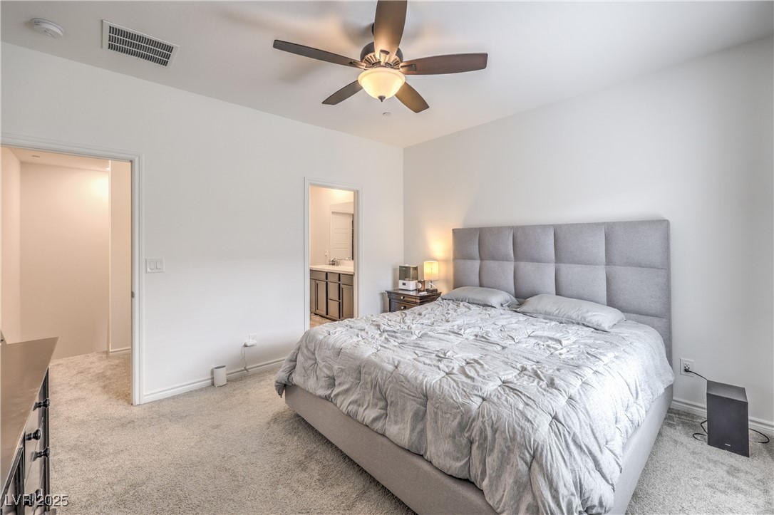 7232 North Decatur Boulevard, Unit 4 North Las Vegas, NV 89084 - Photo 18 of 36 Carpeted bedroom featuring visible vents, connected bathroom, ceiling fan, a sink, and baseboards