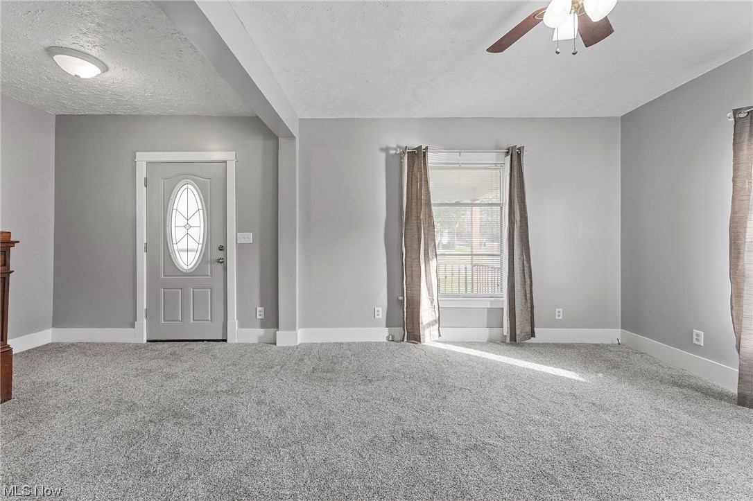6343 Jefferson Road Ashtabula, OH 44004 - Photo 17 of 31 Carpeted foyer entrance with plenty of natural light, a textured ceiling, and ceiling fan