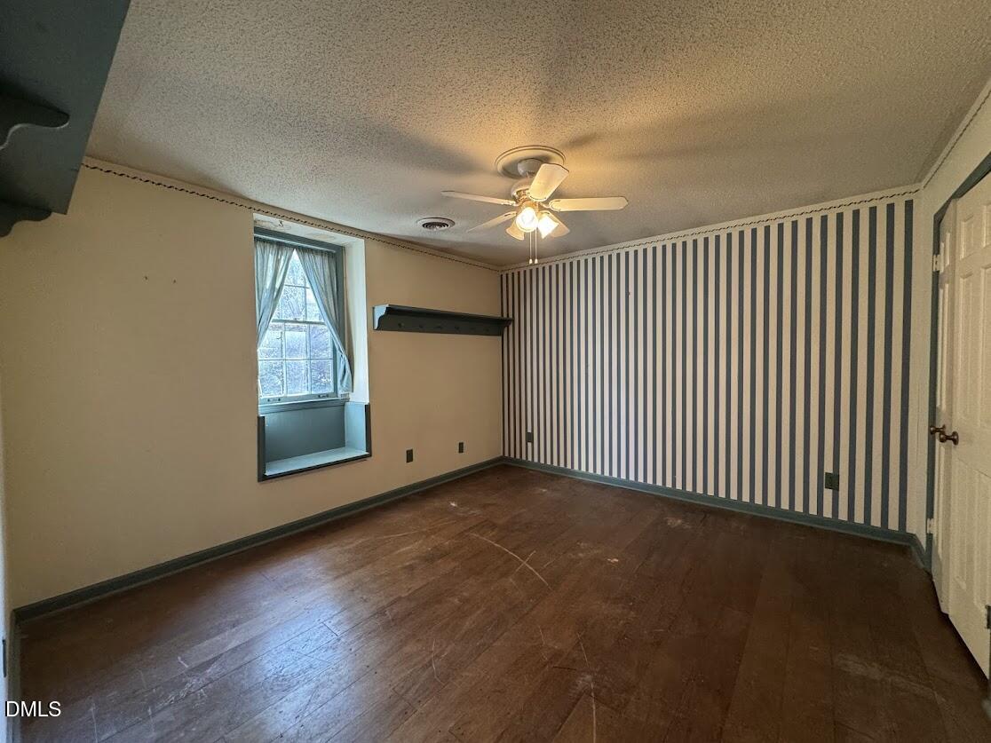 1134 Manchester Drive Cary, NC 27511 - Photo 13 of 15 an empty room with chandelier fan and windows