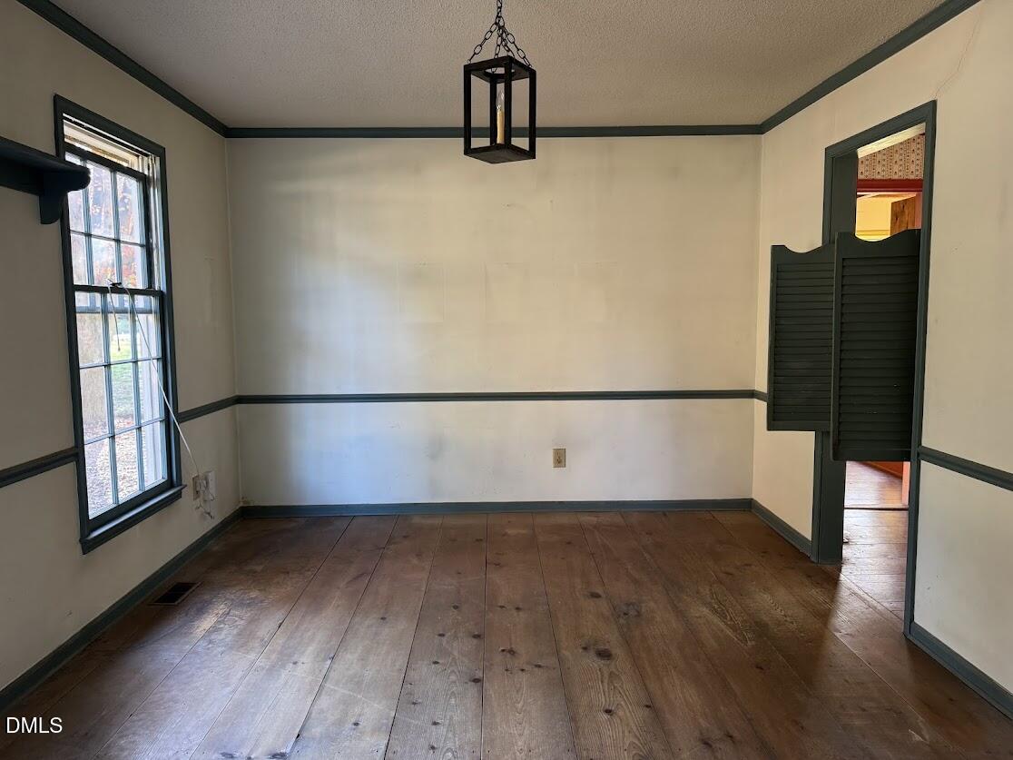 1134 Manchester Drive Cary, NC 27511 - Photo 7 of 15 a view of an empty room with wooden floor and a window