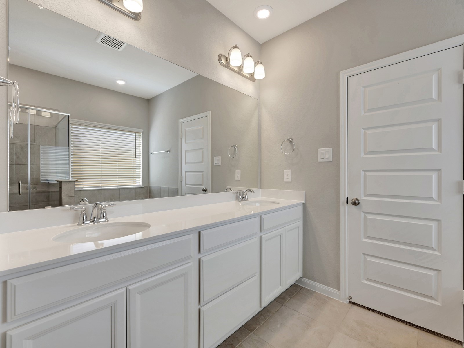 17882 Stone Terrace Montgomery, TX 77316 - Photo 12 of 33 a bathroom with a double vanity sink a mirror and a shower