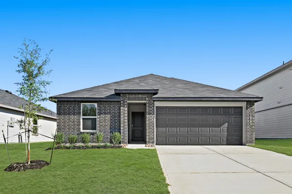 a front view of a house with a garden and yard