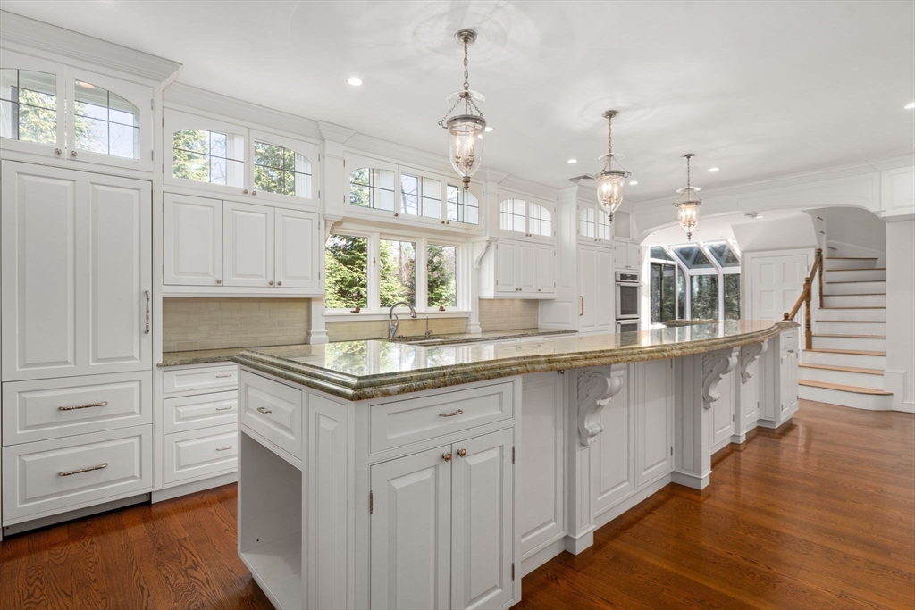 96 Monadnock Road Newton, MA 02467 - Photo 10 of 25 a kitchen with granite countertop a stove a sink a dining table and chairs with wooden floor