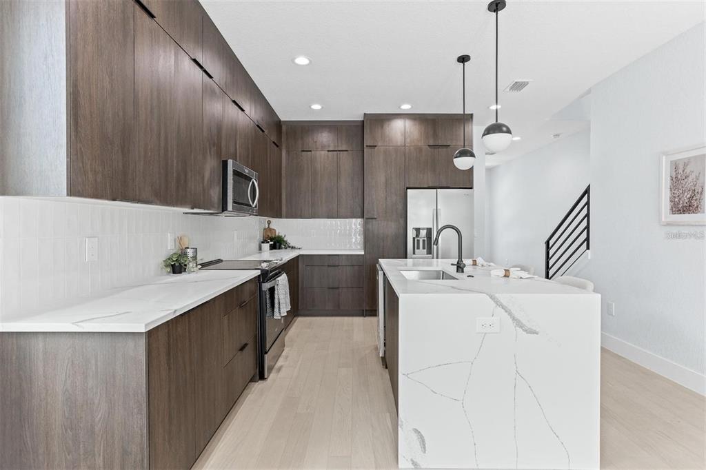 2512 West Chestnut Street Tampa, FL 33607 - Photo 4 of 11 a large white kitchen with a sink a stove and a refrigerator