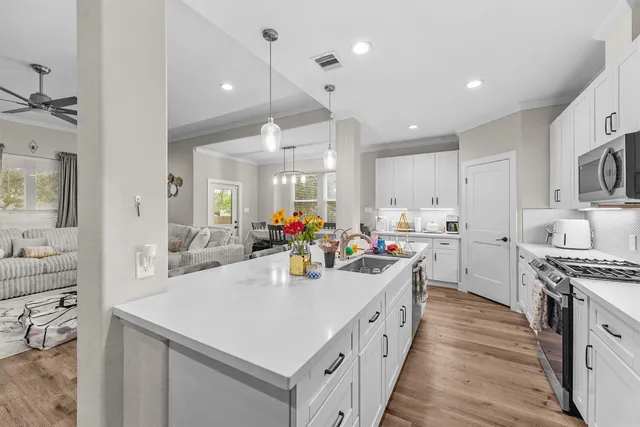 a kitchen with stainless steel appliances a sink stove and cabinets