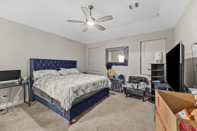 a bedroom with a bed couch and flat screen tv