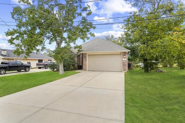 a front view of a house with a yard and trees