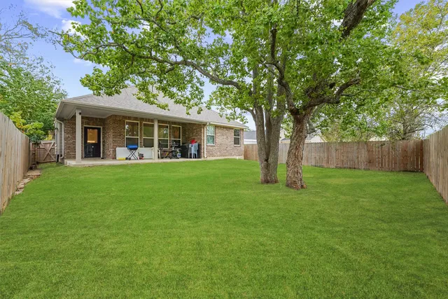 a view of a house with a backyard