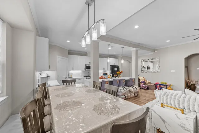 a view of a dining room and livingroom with furniture wooden floor a chandelier