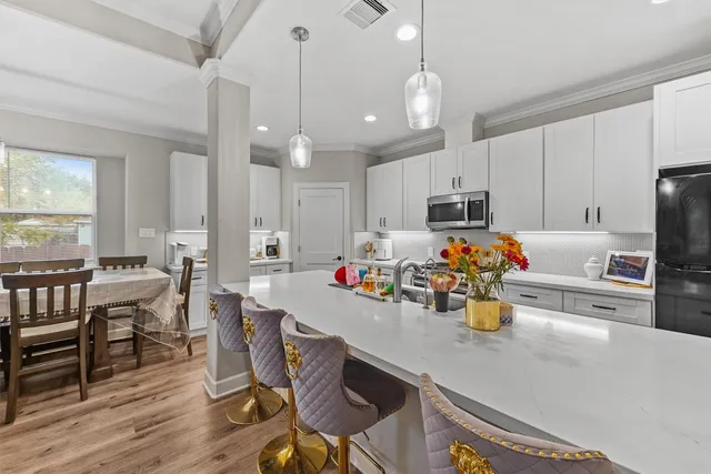a kitchen with a dining table chairs and microwave