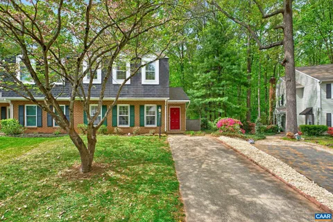a view of a brick house with a large windows and large trees