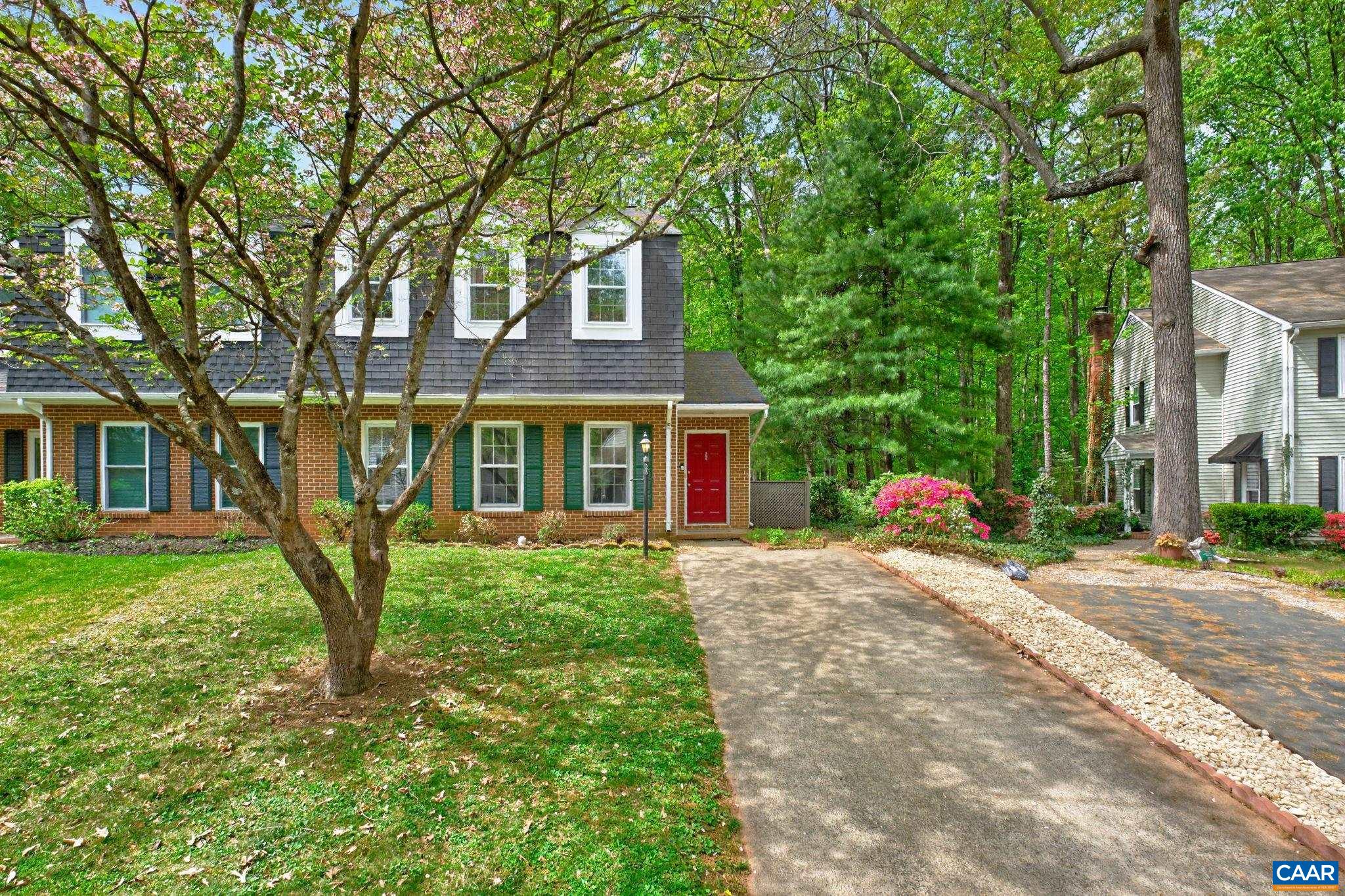 a view of a brick house with a large windows and large trees